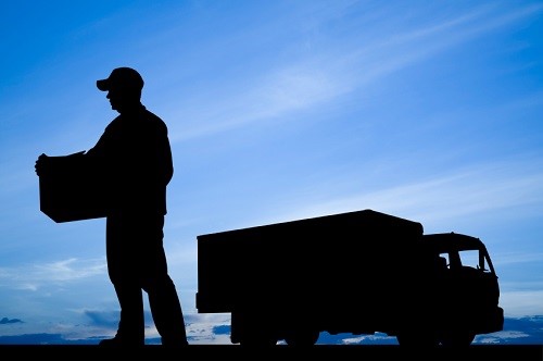 Silhouette of a delivery driver and commercial truck