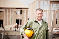 image of man on construction site holding hard hat