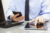 man typing on tablet and phone