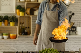 image of man cooking with fire in restaurant
