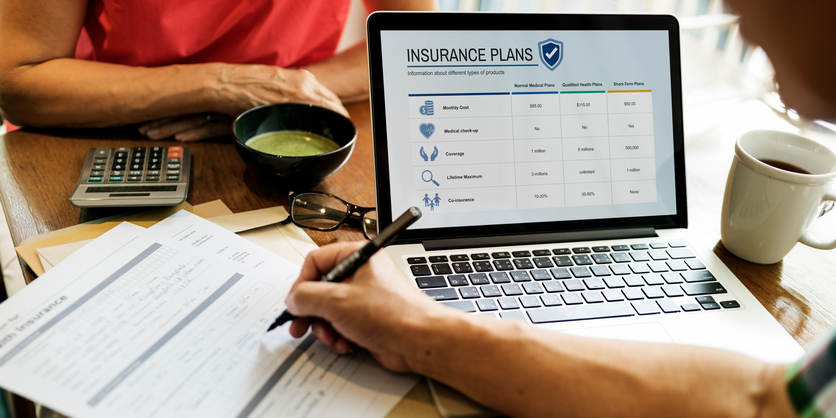 image of man on computer looking at insurance plans