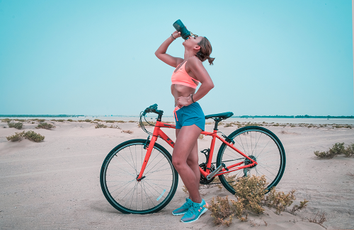 a person riding a bicycle on a beach