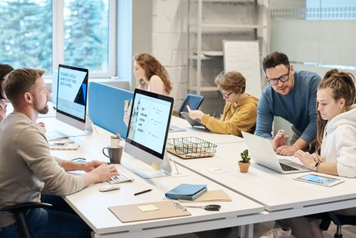 a group of people sitting at a table with a laptop